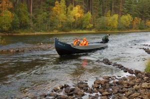 un grupo de personas en un barco en un río en Ahkula House en Lemmenjoki