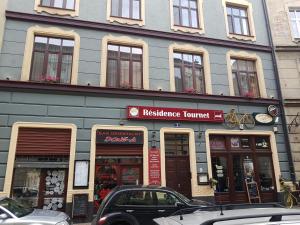 un bâtiment dans une rue avec des voitures garées devant dans l'établissement Résidence Tournet, à Cracovie