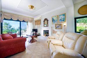 a living room with white furniture and a fireplace at Golden Key Villas in Chania