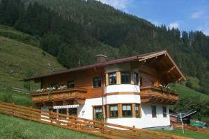 a large house on a hill with a fence at Stöckl Gaby in Rauris