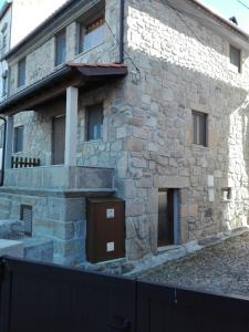 a stone building with a brown door on it at Casa d'Avó Serra da Estrela in Seia