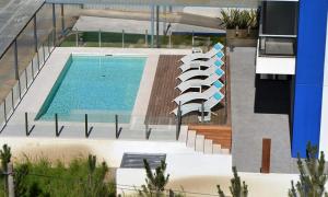 una piscina con algunas sillas y una piscina en Apartamento en Punta del Este, en Punta del Este