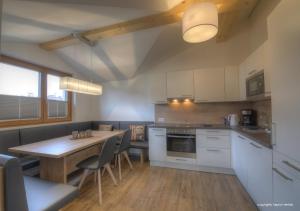 Una cocina con una mesa de madera y una mesa y sillas. en Penthouse Kaprun by Kaprun Rentals, en Kaprun