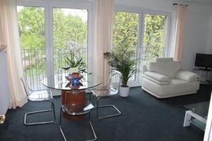 a living room with a glass table and a couch at Hotel Windthorst in Münster