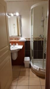 a bathroom with a sink and a shower and a toilet at Contact Hotel Utah Beach Carentan in Carentan +33 photos