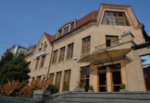 um grande edifício de tijolos com uma escada em frente em Yerevan Deluxe Hotel em Yerevan