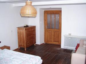 een slaapkamer met een bed, een houten dressoir en een deur bij Jafura in Dolná Turecká