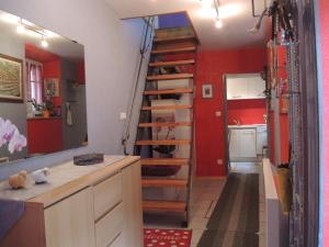 a kitchen with red walls and a spiral staircase at GITE le 70 à TURCKHEIM, 10 min Colmar in Turckheim