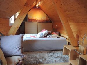 a bedroom with a bed in a wooden attic at GITE le 70 à TURCKHEIM, 10 min Colmar in Turckheim