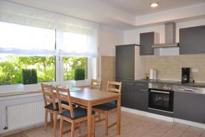 una cocina con mesa de madera y sillas. en FeWo Lilly, en Willingen