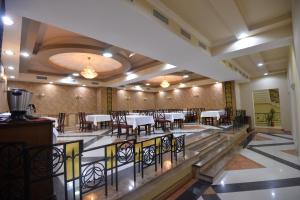 um restaurante com mesas e cadeiras num quarto em Yerevan Deluxe Hotel em Yerevan