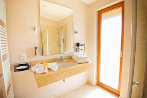 a bathroom with a sink and a mirror at Hotelcamp Reinsehlen in Schneverdingen