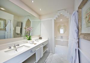 a bathroom with two sinks and a large mirror at Bellevue Syrene in Sorrento