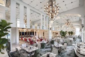 a restaurant with tables and chairs and chandeliers at Crown Towers Melbourne in Melbourne