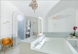 a white bathroom with a sink and a chandelier at Bellevue Syrene in Sorrento