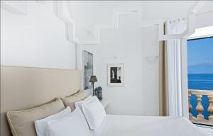 a bedroom with a bed with a view of the ocean at Bellevue Syrene in Sorrento