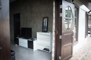 a living room with a door and a television at PK Villa Huahin in Hua Hin