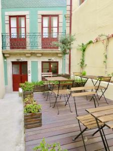 un patio con mesas y sillas frente a un edificio en Porto Republica Riverside en Oporto