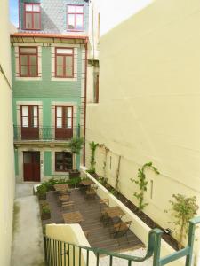 un balcón con mesas y sillas frente a un edificio en Porto Republica Riverside en Oporto