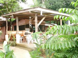 a wooden pavilion with tables and chairs in a garden at Jacobin Hostel & Cabins in Drake