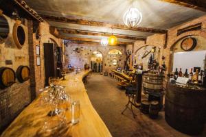 a wine cellar with a long wooden bar with wine glasses at Marani Hotel in Batumi