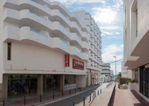 a building with a curved facade on a street at Apartamentos Los Angeles in San Antonio