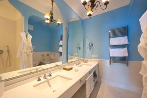 a bathroom with a large mirror and a sink at Bellevue Syrene in Sorrento