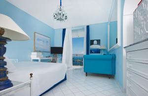 a blue bedroom with a bed and a desk at Bellevue Syrene in Sorrento