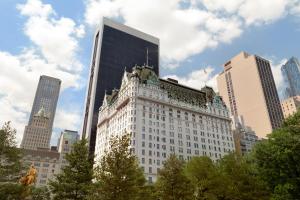 a large white building in a city with tall buildings at The Plaza in New York