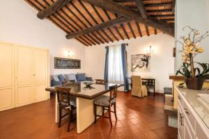 Borgo Tre Rose في Valiano: مطبخ وغرفة معيشة مع طاولة وكراسي