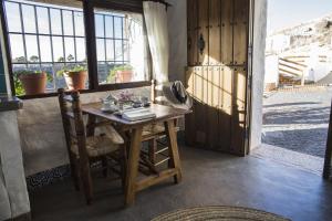 Zimmer mit einem Holztisch und einem Fenster in der Unterkunft Balcones de Piedad in Los Balcones