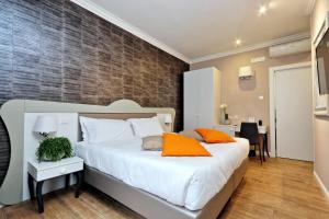 ローマにあるヴィーコ ルームス & テラスのベッドルーム(オレンジ色の枕が付いた大きな白いベッド付)