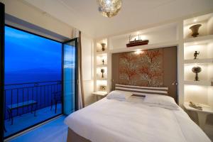 a bedroom with a large bed and a large window at Bellevue Syrene in Sorrento