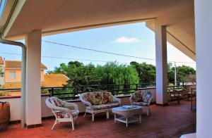 a patio with chairs and a table on a balcony at La Villa delle Spezie in Marzamemi