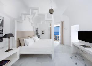 a white bedroom with a bed and a television at Bellevue Syrene in Sorrento