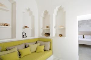 a living room with a green couch with yellow pillows at Bellevue Syrene in Sorrento