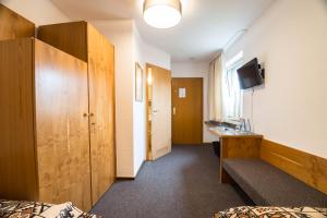a hotel room with a bed and a desk and a tv at Haus Mühlenbrock in Schermbeck
