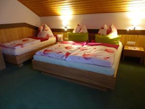 2 Betten in einem Hotelzimmer mit grünen Kissen in der Unterkunft Ferienwohnung Hierzegger in Tauplitz