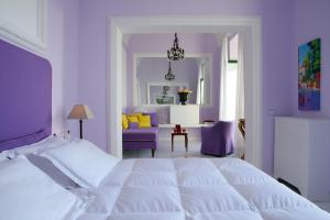 a bedroom with a large white bed and purple walls at Bellevue Syrene in Sorrento