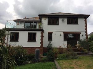 a white house with a balcony on top of it at Olcote House in Padstow
