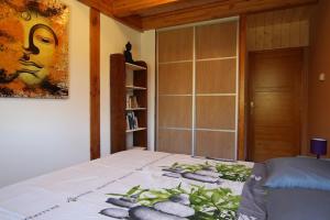a bedroom with a bed with a painting on the wall at Chalet De Crouzillac in Tence