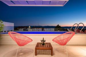 two chairs and a table in front of a pool at Belado Residence Bol in Bol +129 photos