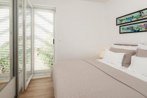 a white bedroom with a large bed and a window at Belado Residence Bol in Bol