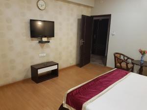 a bedroom with a bed and a tv on the wall at Hotel Sitara Residency in Hyderabad