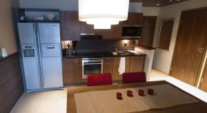 a kitchen with a refrigerator and two red chairs at Holiday Club Tahko Spa Apartments in Tahkovuori
