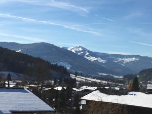 a view of a snowy mountain range with snow covered roofs at Chalet Christine in Brixen im Thale