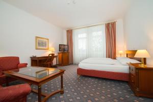um quarto de hotel com uma cama e uma mesa em Parkhotel Styria em Steyr