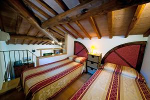 2 bedden in een kamer met houten plafonds bij Podere Oliveta - 5 appartamenti con Piscina e Vista in Poggibonsi +78 foto's