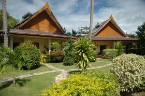 een huis met een tuin ervoor bij Palm Garden Resort in Rawai Beach