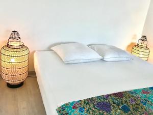 a white bed with two pillows and a lamp at Lakescape Zurich in Herrliberg